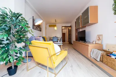 a living room with a yellow chair and a tv at Apartamento con gran patio y excelente ubicación! in Mataró