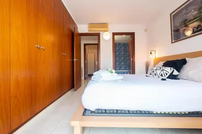a bedroom with two beds and a wooden cabinet at Apartamento con gran patio y excelente ubicación! in Mataró