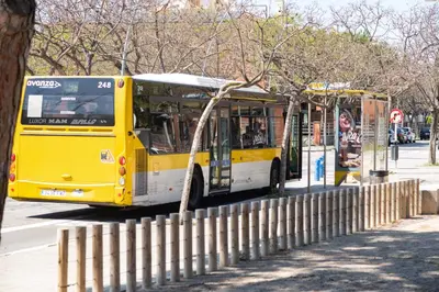 a yellow and white bus parked at a bus stop at Beachfront Sunny Apartment , Sea & Mountain View in Castelldefels