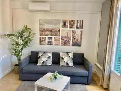 a living room with a blue couch and a table at 2 BDR EIXAMPLE APARTMENT in Barcelona