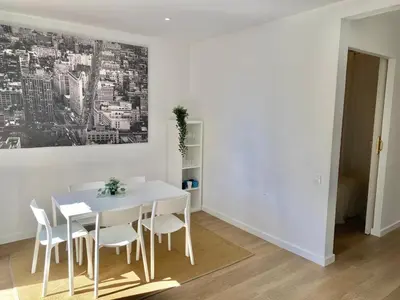 a white dining room with a white table and chairs at 2 BDR EIXAMPLE APARTMENT in Barcelona