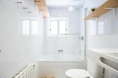 a white bathroom with a toilet and a bath tub at Apartment with terrace a step away from Montjuic, Barcelona in Barcelona