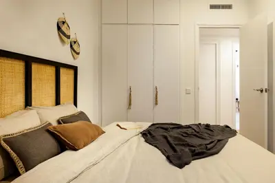 a bedroom with a bed and a mirror and a window at TAMAN - Three Bedroom Apartment in Casanova Street in Barcelona