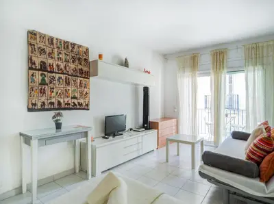 a living room with a couch and a tv at Ferdinand Apartment by Hello Homes Sitges in Sitges