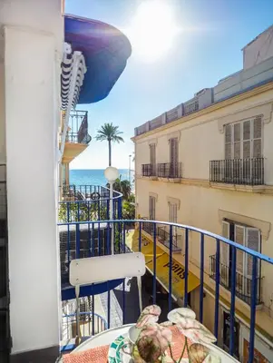 a balcony with a table and a view of the ocean at Ferdinand Apartment by Hello Homes Sitges in Sitges