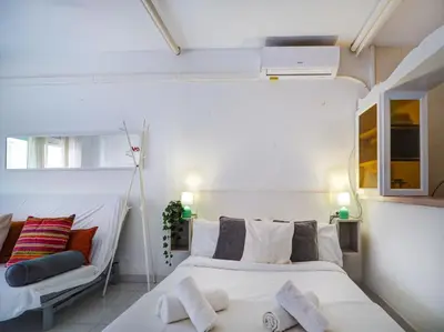 a small bedroom with two beds and a window at Ferdinand Apartment by Hello Homes Sitges in Sitges