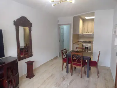 a dining room with a table and chairs and a mirror at Mar & Cunit in Cunit