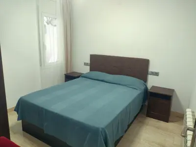 a bedroom with a blue bed and a window at Mar & Cunit in Cunit