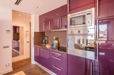 a kitchen with purple cabinets and a microwave at Sweett - Casa Palau in Barcelona