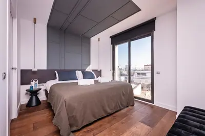 a bedroom with a large bed and a large window at Sweett - Casa Palau in Barcelona