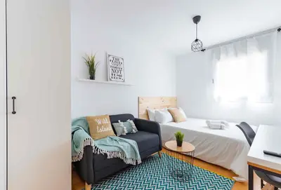 a living room with a bed and a couch at El Capricho Terrassa. in Terrassa