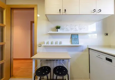 a kitchen with a counter and two stools at El Capricho Terrassa. in Terrassa