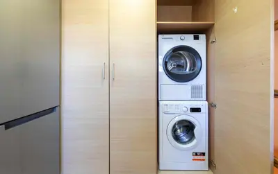 a washing machine and a washer and dryer in a closet at El Capricho Terrassa. in Terrassa