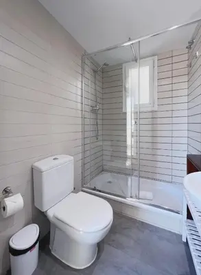 a white bathroom with a toilet and a bath tub at Stay U-nique Apartments Sants II in Barcelona