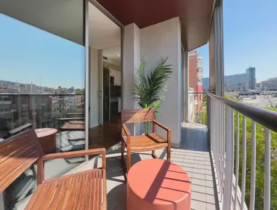 a balcony with wooden benches and a view of a city at Stay U-nique Apartments Sants II in Barcelona
