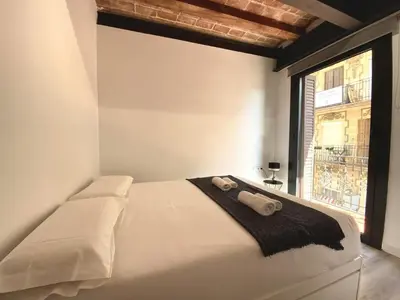 a white bed in a room with a window at Sants Montjuic Olympic View in Barcelona