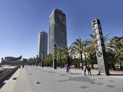 a city street with palm trees and tall buildings at Sunny Playa Apartment in Barcelona