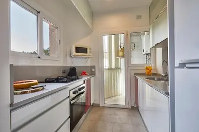 a kitchen with white cabinets and a stove top oven at BBarcelona Modern Eixample Flat in Barcelona
