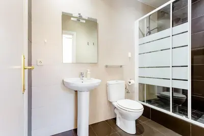 a white bathroom with a toilet and a sink at Casa Lolita in Barcelona
