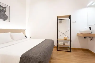 a bedroom with a bed and a bathroom with a sink at Casa Lolita in Barcelona