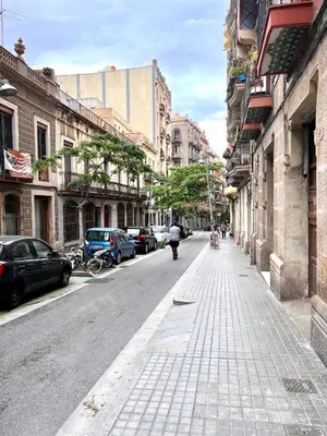 a city street with buildings and a person riding a bike at Poble Sec. Excelente ubicación cerca de la playa y de las Ramblas in Barcelona