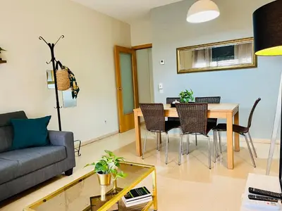 a living room with a couch and a table and chairs at Magic Camp Nou in Barcelona