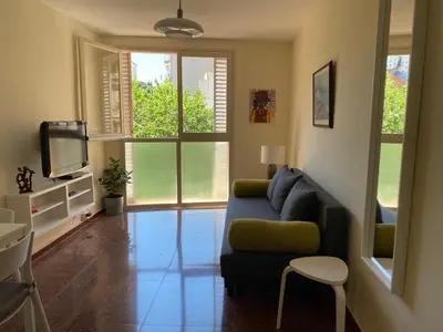 a living room with a blue couch and a tv at Luminoso apartamento en Canet de Mar cercano a la playa y a Barcelona in Canet de Mar