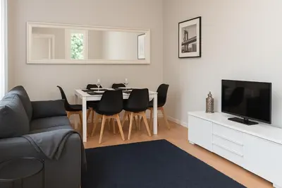 a living room with a table and chairs and a television at Habitat Apartments Batlló in Barcelona