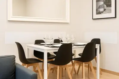 a dining room table with four chairs and wine glasses at Habitat Apartments Batlló in Barcelona