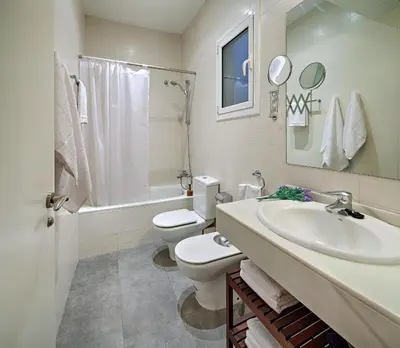 a white bathroom with a sink and a toilet at Habitat Apartments Batlló in Barcelona