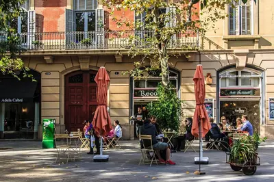 a group of people sitting at tables in front of a building at Habitat Apartments Pedrera in Barcelona