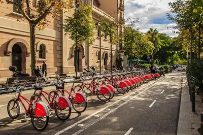 a row of red bikes parked on the side of a street at Habitat Apartments Pedrera in Barcelona
