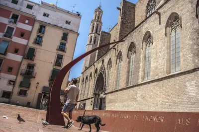 a man walking a dog in front of a building at Habitat Apartments Ferran in Barcelona