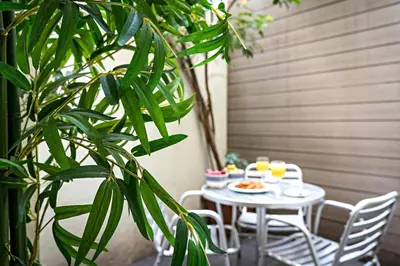 a table with a plate of food on it next to a plant at Habitat Apartments Born in Barcelona