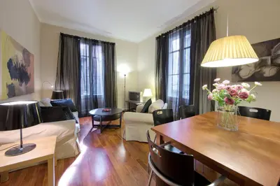 a living room with a couch and a table with flowers on it at Habitat Apartments Art in Barcelona