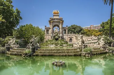 a building with a fountain in the middle of a body of water at Habitat Apartments Carders in Barcelona