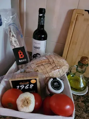 a bag of bread and tomatoes and a bottle of wine at Cal Jamila in Cubelles