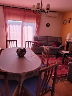 a living room with a table and chairs and a couch at Cal Jamila in Cubelles