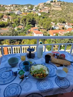 a blue table with a plate of food on a balcony at Cal Jamila in Cubelles