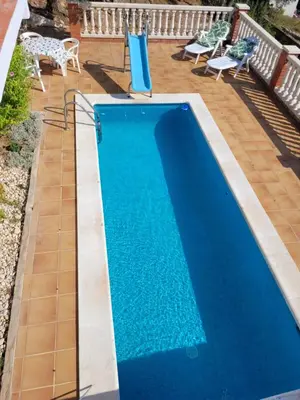 a swimming pool with blue water in a backyard at Cal Jamila in Cubelles