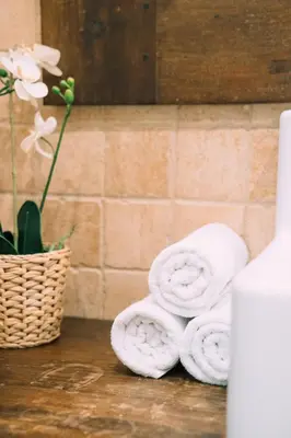 a pile of towels sitting next to a basket of flowers at Cozy Place next to Park Güell in Barcelona