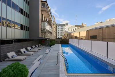 a balcony with white couches on a building at Catalonia Square 4* Sup in Barcelona