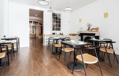 a dining room with tables and chairs and a fireplace at Divino Hotel Boutique in Sitges