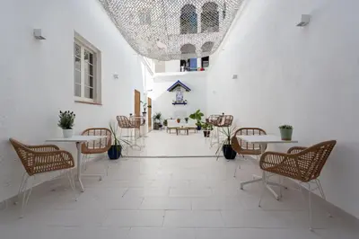 a corridor with tables and chairs in a building at Divino Hotel Boutique in Sitges