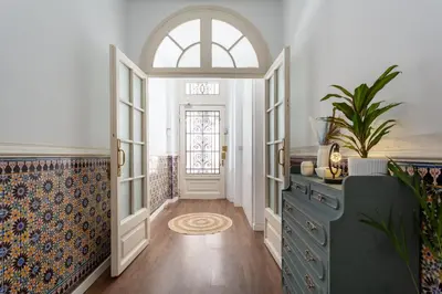 a hallway with an arched window and a blue dresser at Divino Hotel Boutique in Sitges