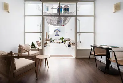 a living room with large windows and a table and chairs at Divino Hotel Boutique in Sitges