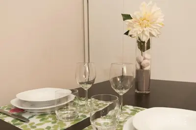 a table with glasses and plates and a vase with flowers at True Design in Heart of Noble BCN in Barcelona