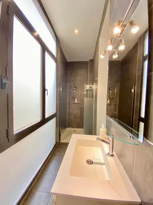 a bathroom with a sink and a shower and a window at True Design in Heart of Noble BCN in Barcelona