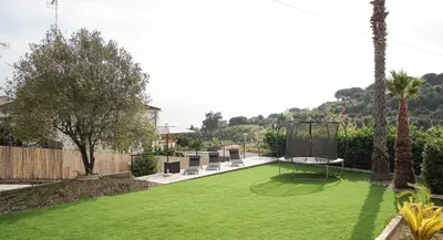 a backyard with a green lawn and a swing at Holidays en Arenys de Mar y Montaña in Arenys de Mar