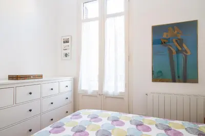 a bedroom with a bed and a dresser and a window at Barcelona cozy apartment in Barcelona